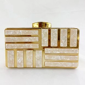 Detail of evening clutch with gold metal frame and white geometric pearl-like panels