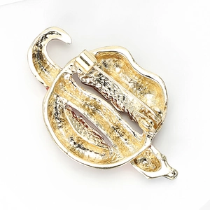 Macro view of gold alloy brooch showing textured surface and back safety pin clasp