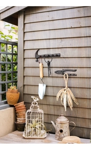 Close-up of vintage cast iron hammer and pliers wall hooks on a rustic wooden background
