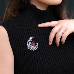 Elegant crescent moon brooch with purple crystal and colorful rhinestones on black sweater