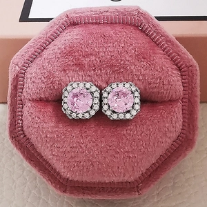 Macro view of pink zircon stud earrings featuring halo setting in a pink velvet jewelry box