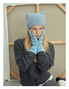 Detailed knit texture of light blue cat ear hat with bow and matching long gloves
