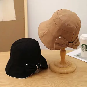 Dettaglio dell'elegante fiocco con fibbia in metallo sul cappello da sole pescatore kaki