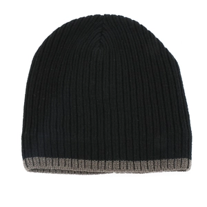 Detailed close-up of ribbed knit texture on a black and grey striped beanie hat