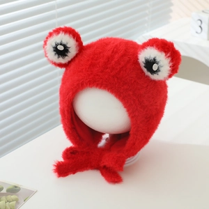 Close-up of red plush frog hat with tie-up straps and fuzzy faux fur texture