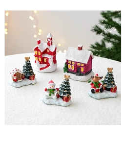 Miniature resin Christmas scene with cottage, snowman, and reindeer on a snowy base