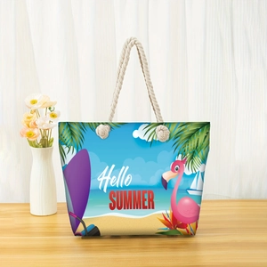 Detail of Hello Summer beach tote bag with flamingo print and rope handles on wood table