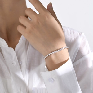 Elegant gold-plated tennis bracelet with sparkling zircon stones worn on a female wrist