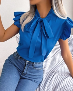 Detail of blue chiffon blouse featuring elegant bow neck and ruffled butterfly sleeves