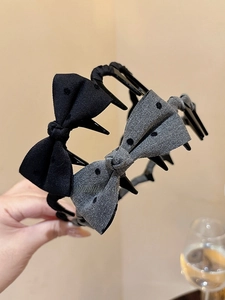 Close-up of polka dot bow headbands with toothed grips in black and gray tones