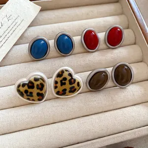 Elegant acrylic leopard heart and oval stud earrings set on a velvet jewelry tray