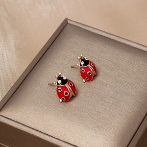 Boucles d'oreilles coccinelle en émail rouge et finition dorée sur boîte