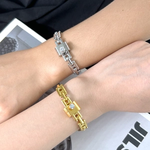 Detail of gold and silver chain bracelets featuring rhinestone encrusted clasps
