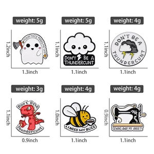 Collection of cartoon enamel pins featuring dinosaur, bee, and sewing machine designs