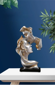 Detail of silver Nordic abstract sculpture depicting a kissing couple with gold accents