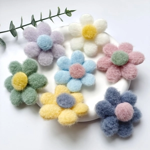 Colorful felt flower accessories set for brooches and hair clips on a white tray