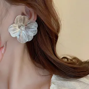 Minimalist silver flower stud earrings with pearl center and hollow petal design