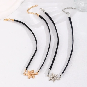 Detail of four velvet chokers featuring gold and silver snowflake charms with small crystals