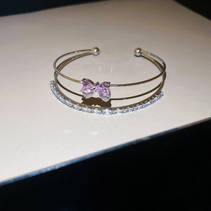 Silver-finish double-layer open bangle with pink crystal bow and rectangular zircon stones