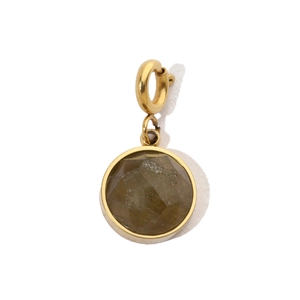 Detail of a faceted dark stone set in a round gold metal base pendant