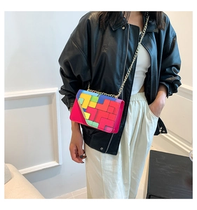 Detail of colorful geometric block pattern and golden chain strap on a crossbody bag