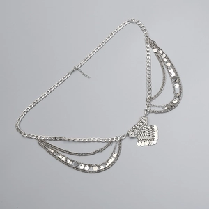 Detail of silver bohemian metal waist chain with layered chains and ethnic charms