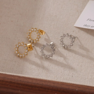 Boucles d'oreilles élégantes tournesol dorées et argentées sur tissu beige doux