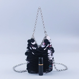 Detail of black sequin mini bag with metallic fish scale texture and silver chain strap