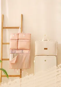Dettaglio dell'organizzatore da viaggio sospeso rosa con tasche a rete e borsa beige
