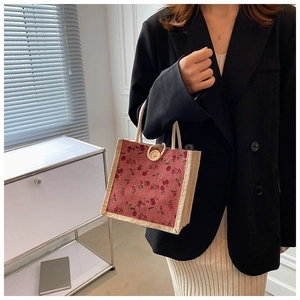 Detail of vintage floral small square bag with wooden button closure and woven handle