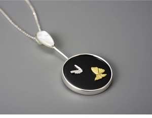 Detailed macro view of an elegant S925 silver butterfly pendant with white mother of pearl