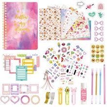 Plano cenital de cuaderno de espiral rosa y púrpura con pegatinas, bolígrafos y cintas