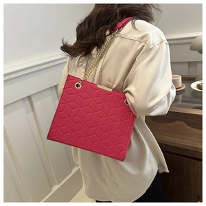Detail of rose pink tote bag featuring 3D geometric quilted pattern and gold chain strap