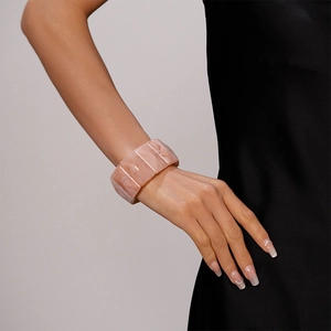 Detail of pink marble resin bangle with a segmented structure on a model wrist