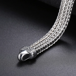 Detailed macro view of the silver dragon scale weave pattern and retro clasp on a men's bracelet