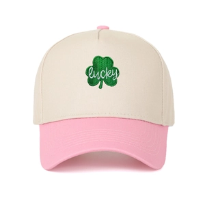 Detail of green leaf embroidery and white lucky script on beige and pink trucker cap