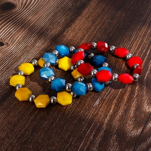 Bohemian style colorful resin bead bracelets with metallic accents on wooden surface