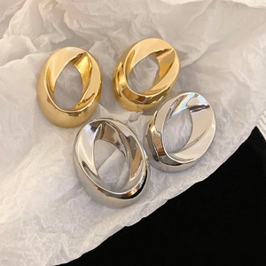 Minimalist twisted oval hoop earrings in polished gold and silver metal finishes