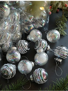 Detail of 6cm iridescent Christmas ball with white glitter stars and silver snowflake cap