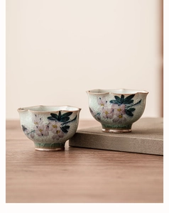 Gros plan d'un mug à thé en céramique avec glaçure craquelée et magnolia peint à la main