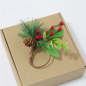 Christmas napkin ring with pine cones, red berries, and green needles on kraft gift box