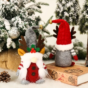Kerstkabouters met elandgewei van pluche en bellen in een sfeervol winters boslandschap