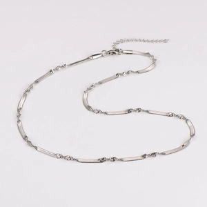 Close-up of silver snake bone chain necklace with twisted texture and lobster clasp detail