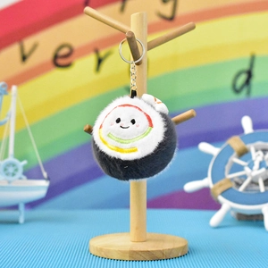 Detail view of a cute sushi plush keychain pendant hanging on a wooden display stand.