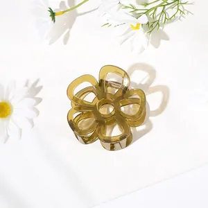 Detailed top view of an olive green translucent resin flower claw clip with gold spring