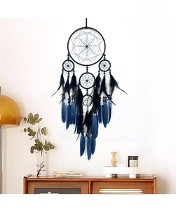 Détail d'un attrape-rêves bleu foncé avec plumes sur un mur blanc de style minimaliste