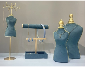 Detail of teal velvet jewelry display stands with gold metal accents for boutiques