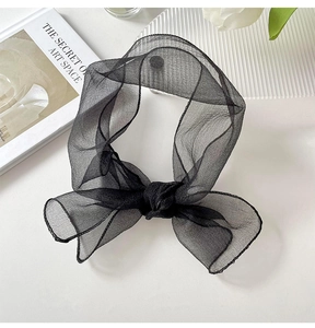 Detail of a black organza ribbon scarf bow with elegant translucent mesh fabric and stitching