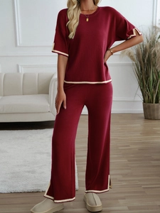 Detail of burgundy knitted set with beige and gold stripe piping on short sleeve top