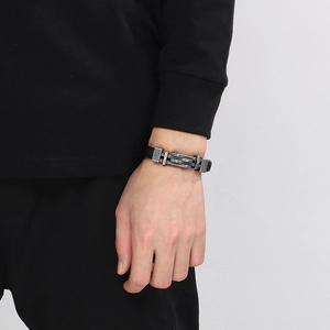 Dettaglio del bracciale in pelle intrecciata nera con chiusura in acciaio inossidabile